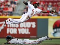 051515 REDS-GIANTS Friday, May 15, 2015. CINCINNATI Cincinnati Reds second baseman Brandon Phillips (4) leaps to save a wild pick-off throw down to second base as San Francisco Giants shortstop Brandon Crawford (35) slides in safely on a steal during the top of the second inning of the MLB game between the Cincinnati Reds and the San Francisco Giants at Great American Ballpark in Cincinnati, on Friday, May 15, 2015. After three innings, the Reds trailed the Giants, 6-1. (The Enquirer/Sam Greene)